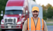 © Volodymyr - Truck driver with large semi-truck trailer. Delivery business. Worker before a long-distance trip. Cargo trailer and truck driver. Business driver near a truck.