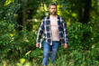 © Volodymyr - Handsome man or lumberjack in checkered shirt hold axe. Lumberjack or woodman. Masculinity concept. Man brutal strong attractive guy cutting wood with axe in forest. Lumberjack with big axe in forest.