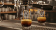 © ATRA - Espresso being poured into glasses on a coffee machine counter in a cafe from a close-up viewpoint
