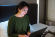 © leungchopan - Woman use laptop on bed at night