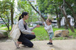 © leungchopan - Mother watching toddler playing with stick outdoors