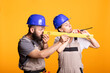 © DC Studio - Bearded man examines yellow measuring level as woman works with screw, showing teamwork in construction industry. Male builder focuses carefully on accuracy, precision and professional craftsmanship.