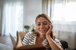 © Migma_Agency - Young woman smiling enjoying reading book at home