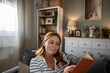 © Migma_Agency - Young woman relaxing reading book at home