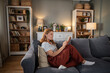 © Migma_Agency - Woman relaxing at home, reading book on sofa