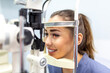 © Graphicroyalty - Young woman having eye exam with slit lamp. Patient in ophthalmology clinic using diagnostic equipment for vision test. Optometry and healthcare concept. Professional eye sight examination.