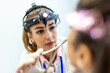© Graphicroyalty - Doctor with medical headlamp. Physician examination, People with specialty health problem, Healthcare And Medicine concept. Female physician wearing ENT head mirror light during a patient visit.