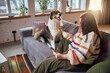 © master1305 - Happy dog sitting on sofa with woman using tablet at home. Concept of pet friendly lifestyle, remote work visuals, online shopping for pets and digital content for animal brands.
