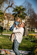 © ADDICTIVE STOCK - Father lifting daughter in sunny park