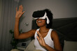 © Westend61 - Woman using VR glasses in bed during evening leisure time