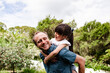 © NZstockphoto - Dad carrying daughter on a piggyback in the backyard
