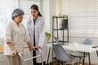 © Rakchanok - Senior mobility rehabilitation, healthcare professional helps patient practice steps with walker, balance control, fall prevention guidance, monitoring results, follow up schedule, elderly wellness
