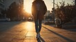© Iryna - Person walking along city street at sunset, warm backlight, urban lifestyle, concept of walking, freedom, calm and modern life