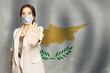 © artmim - Confident woman in medical mask showing stop gesture open palm hand against flag of Cyprus background