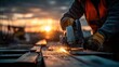 © Micro Pix - Construction worker using a circular saw to cut material at sunset with sparks flying