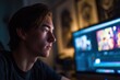 © Bargais - A young man sitting at a computer and working on editing a video.
