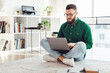 © Prostock-studio - Man Using Laptop Computer Sitting On Floor Wearing Glasses, Working Online Browsing Internet And Typing At Home. Distance Job, Technology And Freelance Career Concept