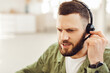 © Prostock-studio - Side View Portrait Of Male Hotline Operator Wearing Headset Making Video Call Talking And Communicating With Customers Indoors. Modern Remote Communication Concept