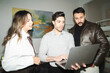 © Studio Marmellata - Three colleagues collaborate on a project, gathered around a laptop. They are engaged in discussion and problem-solving, working together to achieve a common goal.