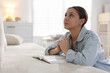 © New Africa - Religion. Woman with Bible praying at home, space for text