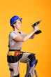 © DC Studio - Female builder stands on ladder while preparing to use power drill in studio. Woman contractor maintains focus and controlled posture, demonstrating precision and hands on skill in renovation project.