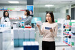 © DC Studio - Adult woman stands in local pharmacy aisle reading medication packaging while comparing products on store shelves. Calm retail setting highlights responsible healthcare choices and everyday self care.