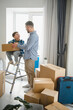 © Serhii - Father and son moving to new home unpacking boxes