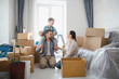 © Serhii - Family celebrating moving into new home with cardboard boxes