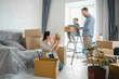 © Serhii - Family moving into new home unpacking cardboard boxes