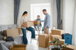 © Serhii - Happy family moving home packing cardboard boxes