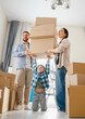 © Serhii - Family moving into new home with cardboard boxes