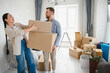 © Serhii - Happy couple moving into new home carrying boxes