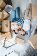 © Serhii - Family relaxing on floor surrounding moving cardboard boxes