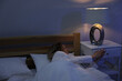 © New Africa - Woman turning on night lamp before sleep in bedroom