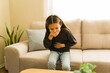 © AntonioDiaz - Tween girl feeling unwell suffering from stomach ache and nausea at home, experiencing sickness problems