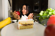 © AntonioDiaz - Latin woman choosing between apple and cake seen from inside refrigerator illustrating healthy eating and willpower concept