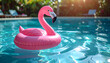 © momostudio - Pink flamingo pool float in a serene swimming pool.
