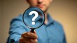 © Noah - Man holding magnifying glass with question mark symbol,close up investigation and research concept with blurred background,curiosity,doubt and problem solving idea