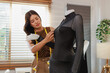 © crizzystudio - Fashion designer adjusting dress on mannequin for new collection