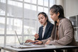 © Apichat - Asian businesswomen collaborating on laptop during office meeting