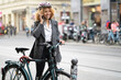 © Westend61 - Smiling woman with bicycle talking on the phone in the city, Berlin, Germany