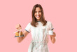 © Pixel-Shot - Happy young female barista with cup of coffee and cake on pink background