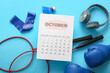 © Pixel-Shot - Composition with paper calendar, sports equipment and modern headphones on color background