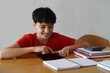 © Inspiraciones - Education and technology. Preteen boy smiling, using a tablet during their homework.