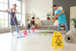 © Pixel-Shot - Team of janitors mopping floor in room