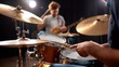 © CreativeArt - Drummer's hands during a music lesson, tapping a drumstick on a drum with a teacher pointing, practicing rhythm