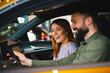 © djile - Excited couple exploring dashboard of their new car