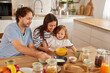 © Stockphotodirectors - A joyful family is gathered in a warm kitchen, cooking breakfast together. The parents actively involve their child in the meal prep, sharing smiles and fostering connection.