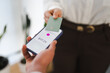 © Studio Marmellata - A person holds a smartphone displaying a payment amount of $17.25, while another person presents a card to complete the transaction.