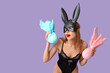© Pixel-Shot - Sexy surprised young woman in bunny mask with Easter gifts on lilac background